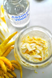 A vodka bottle and buddhas hand citrus fruit with a glass jaar 