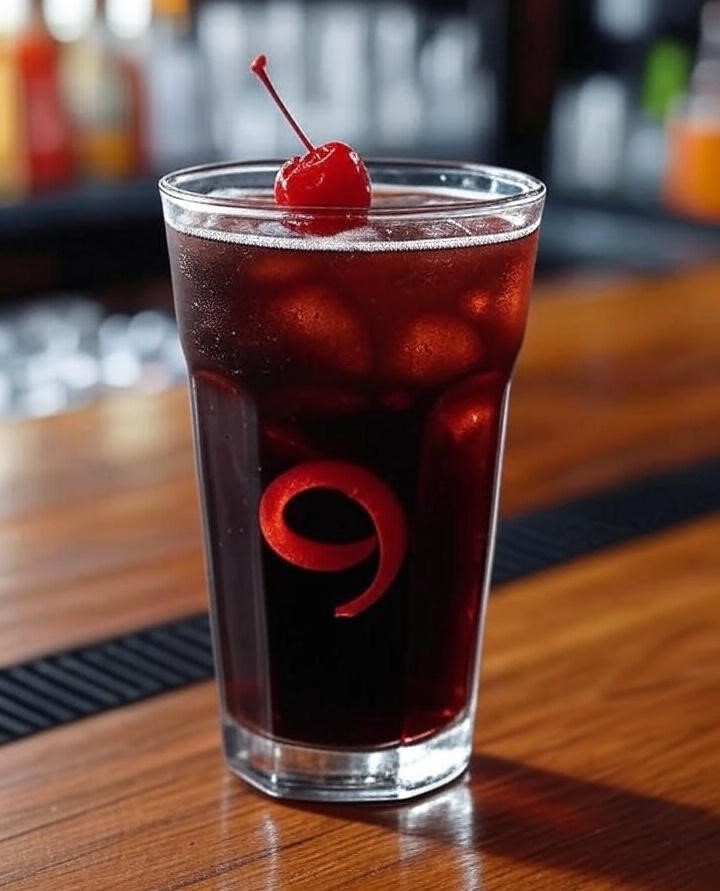 A glass of Cola ice cubes , cherry juice with topping dried cherry