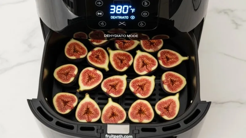 How to dry figs in an air fryer at home showing halved figs arranged in a single layer in the basket for quick drying.”